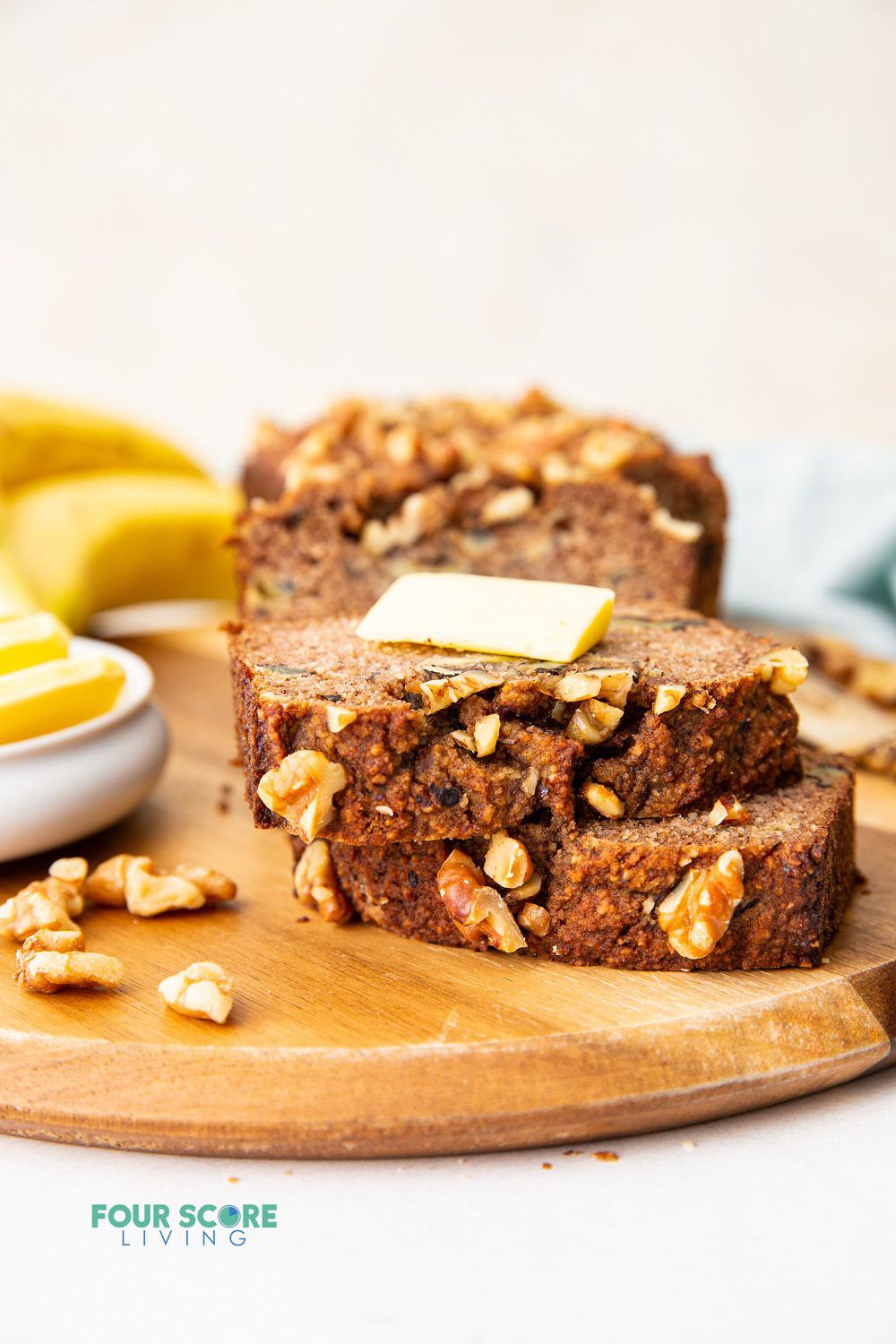 two slices of keto banana bread stacked, with a pat of butter on top.