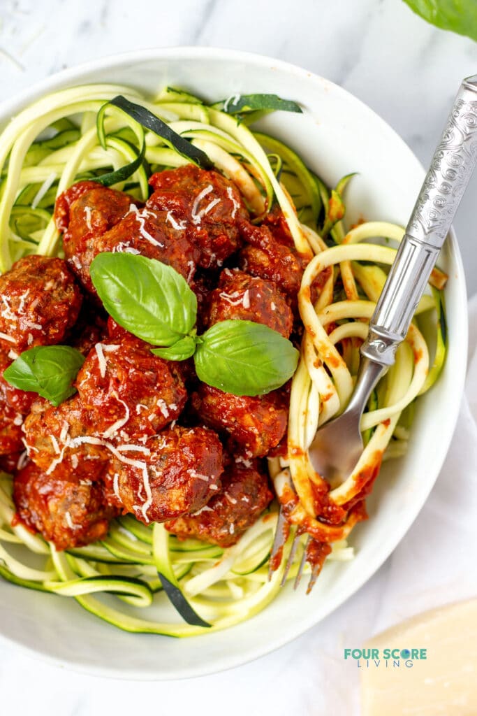 keto meatballs over zoodles with a fork
