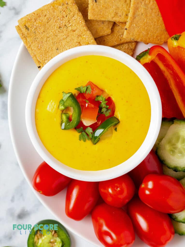 top down view of keto queso in a white bowl with dippers