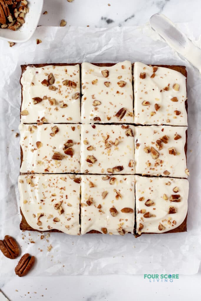 keto carrot cake bars with keto frosting and chopped nuts on top