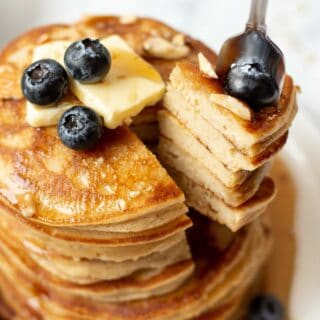 a fork taking a bite out of a stack of keto pancakes