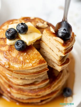 a fork taking a bite out of a stack of keto pancakes