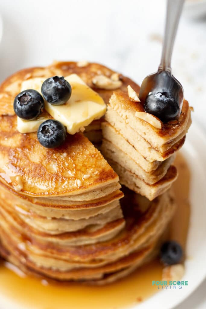 a fork taking a bite out of a stack of keto pancakes