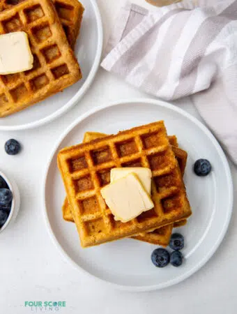 top down view of almond flour waffles on a white plate topped with butter