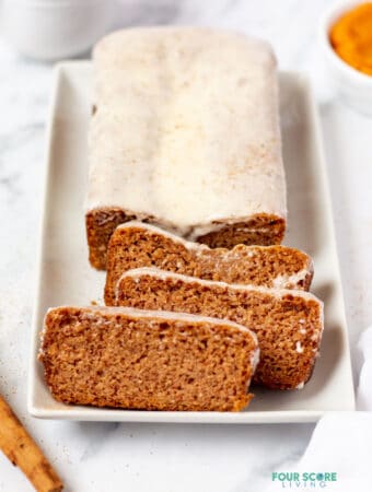 keto pumpkin bread with icing on a white plate