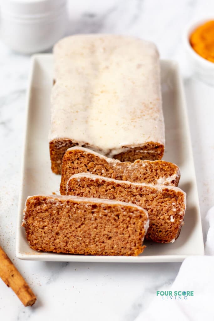 keto pumpkin bread with icing on a white plate