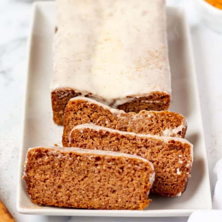 keto pumpkin bread with icing on a white plate