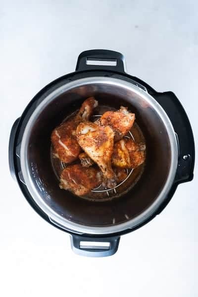 Top view photo of chicken legs in the pot of the Instant Pot, fully cooked.