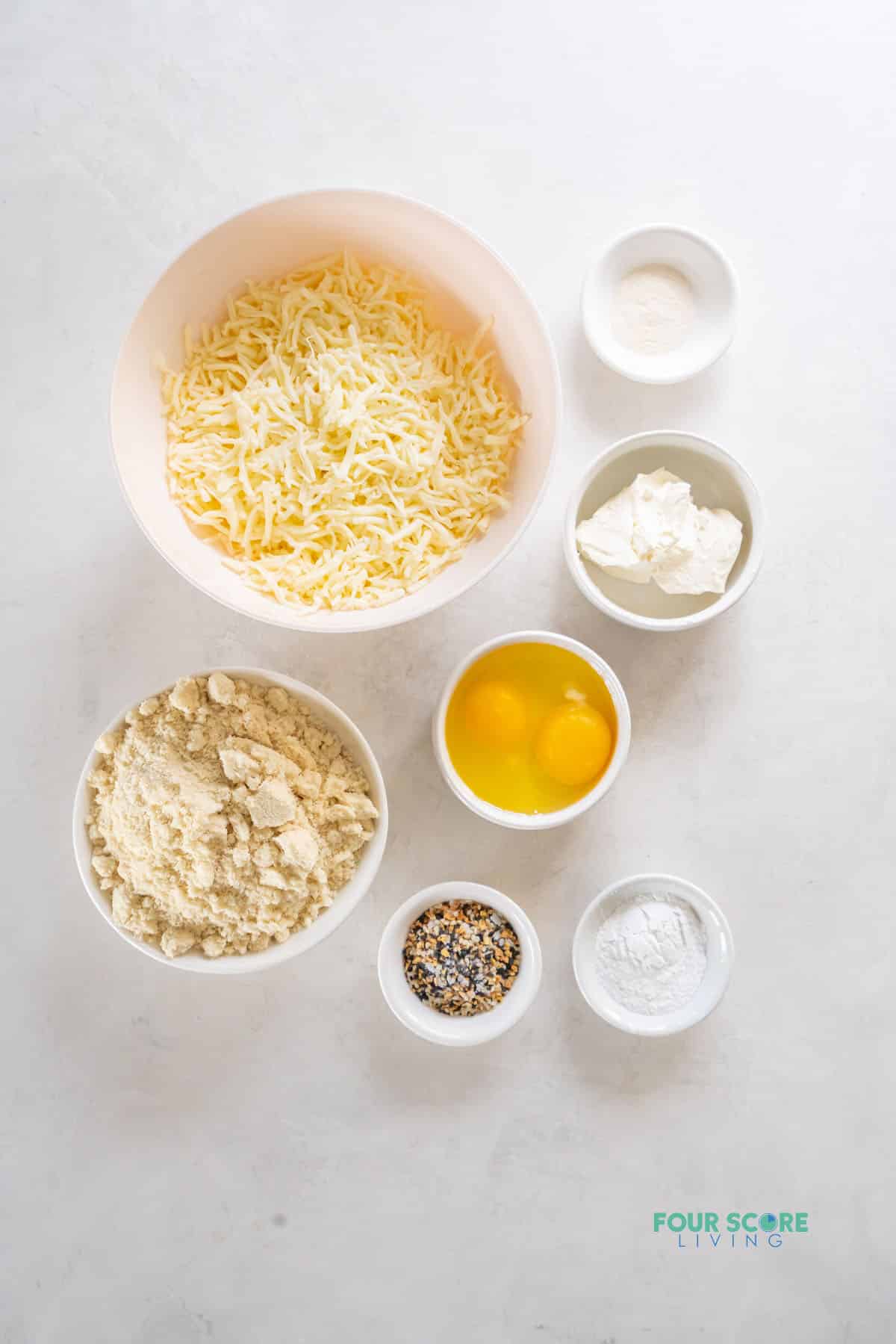 The ingredients needed to make keto bagels, all in separate bowls on a counter, viewed from above
