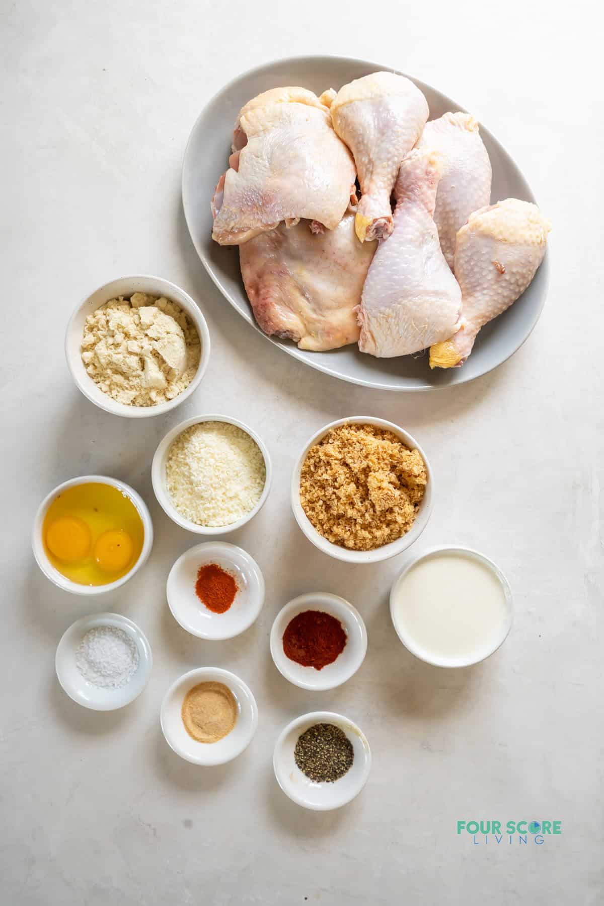 The ingredients needed to make crispy keto fried chicken, all the seasonings are measured into separate small bowls, viewed from above.