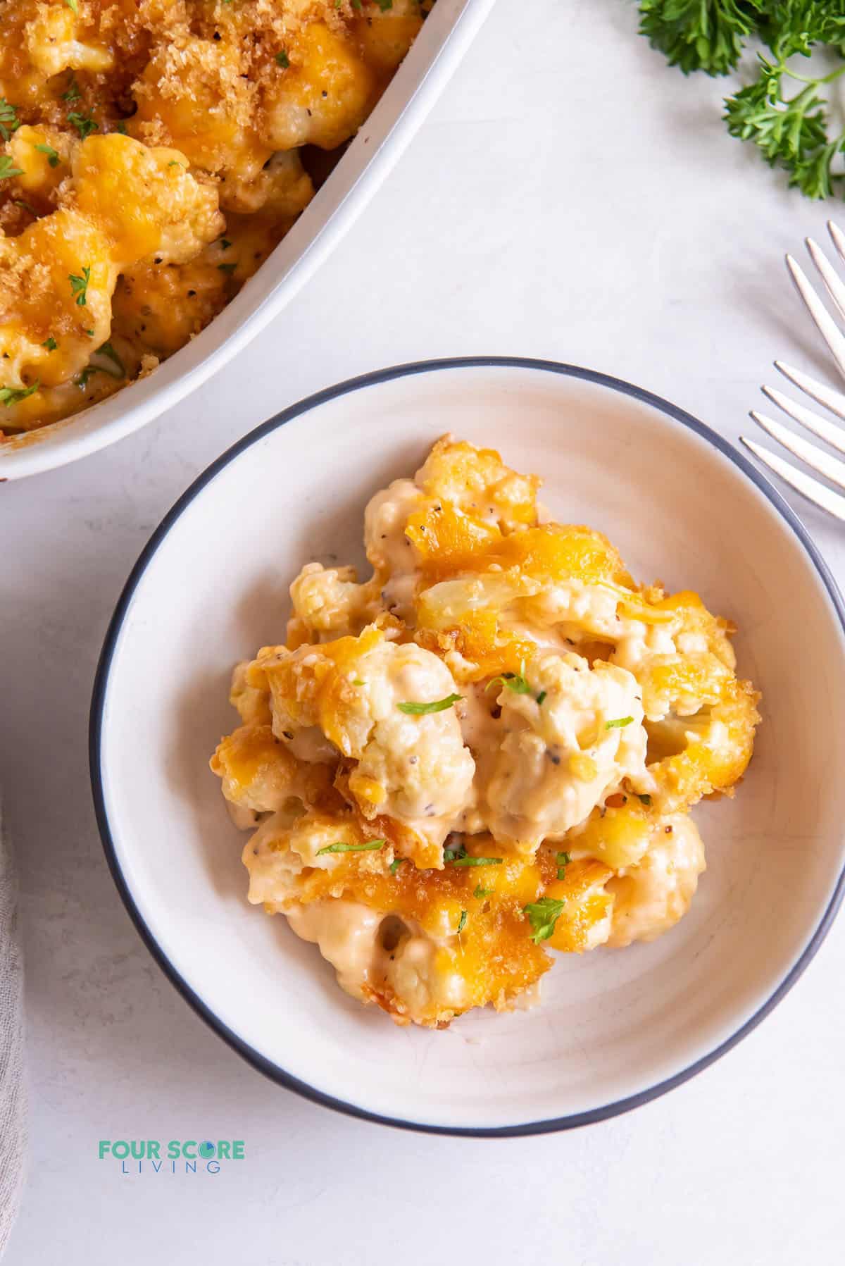 a small bowl with a serving of keto cauliflower mac and cheese in it, viewed from above