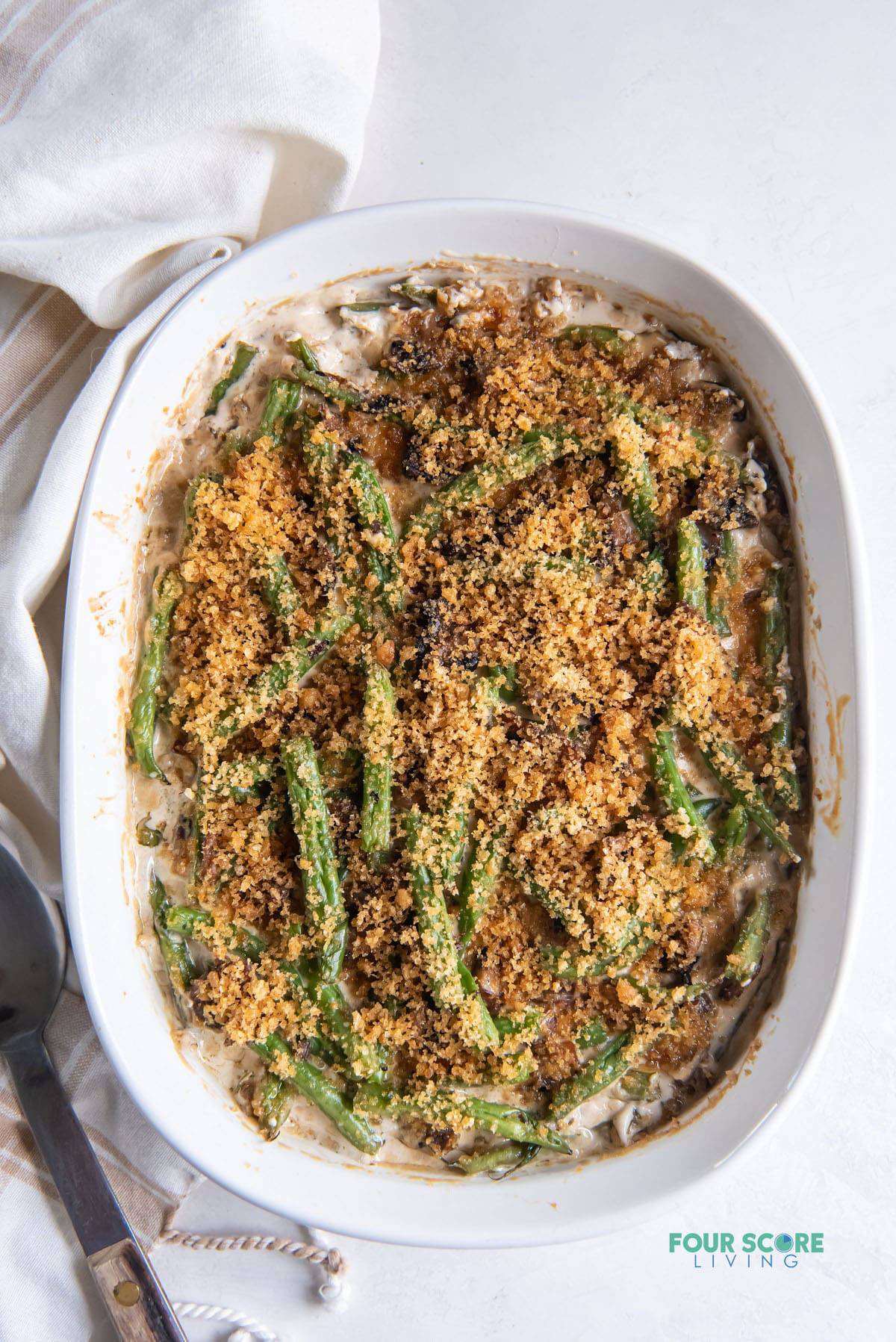 a white oval casserole dish filled with homemade keto green bean casserole, viewed from above