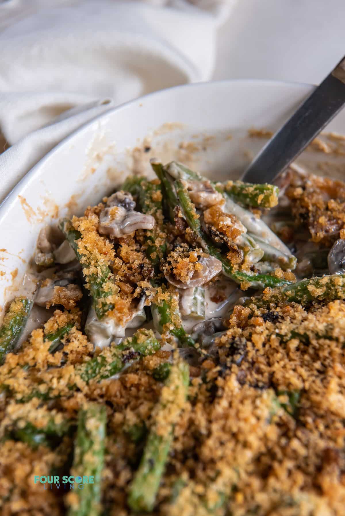 closeup view of a pan of keto green bean casserole topped with crunchy crumbs