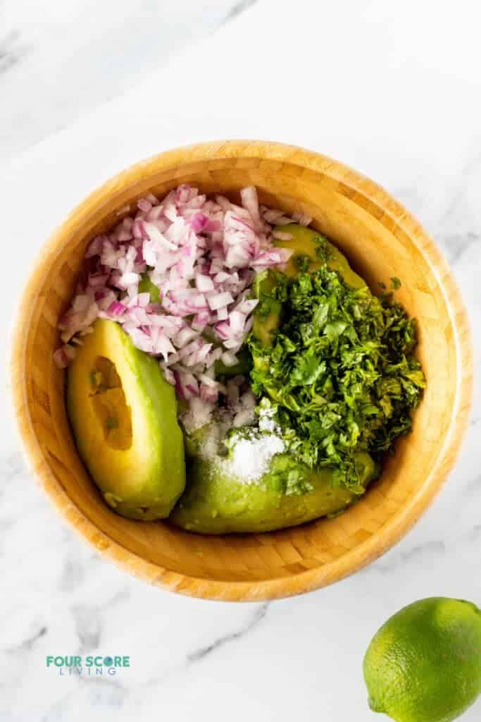 ingredients in 4 ingredient guacamole in a bowl ready to mix together