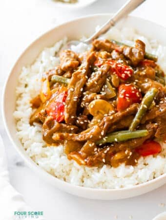 a bowl of rice with black pepper angus steak stir-fry on top
