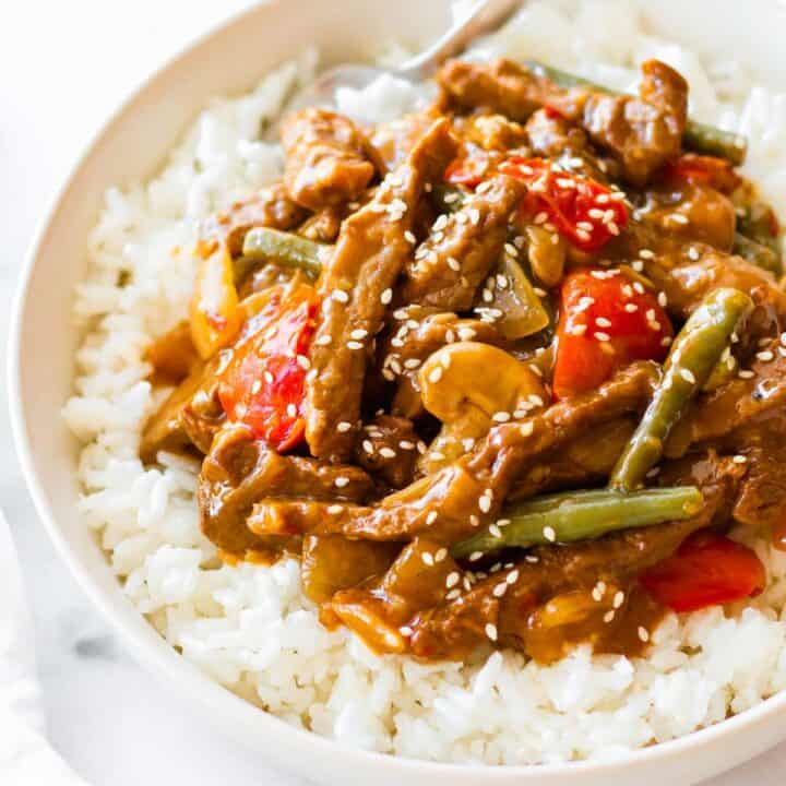 a bowl of rice with black pepper angus steak stir-fry on top