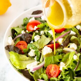 an image of sugar free salad dressing being poured on top of a fresh garden salad