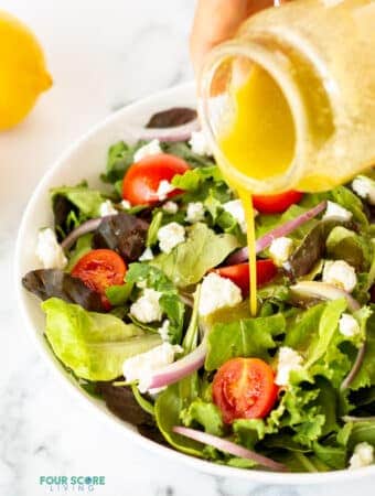 an image of sugar free salad dressing being poured on top of a fresh garden salad