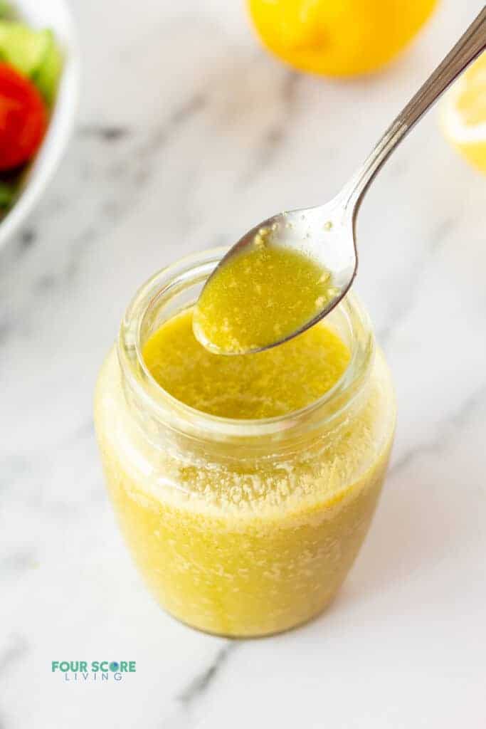 a picture of a spoon dipped in a jar of sugar free salad dressing