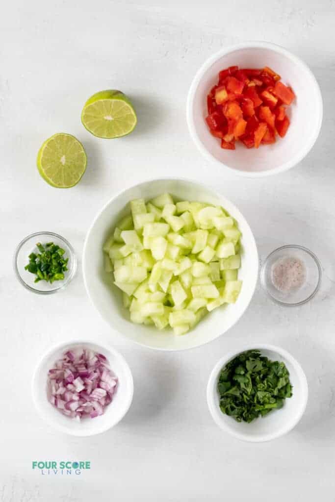 Top view photo of ingredients to make Cucumber Salsa, chopped and in separate bowls.