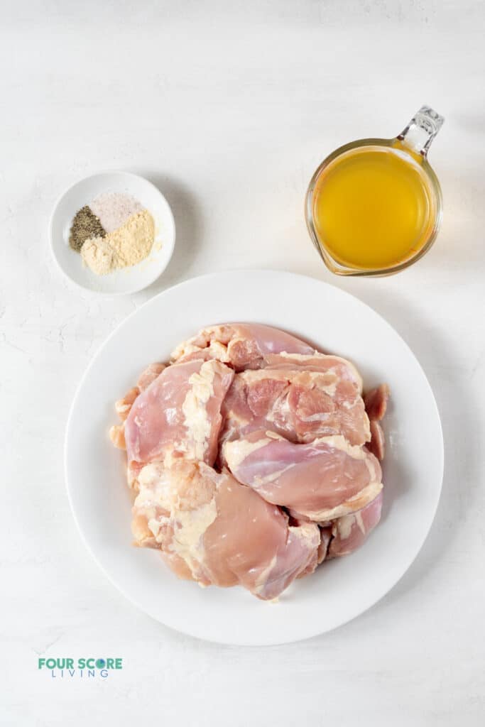 Top view photo of the ingredients to make Instant Pot Shredded Chicken, in separate containers.