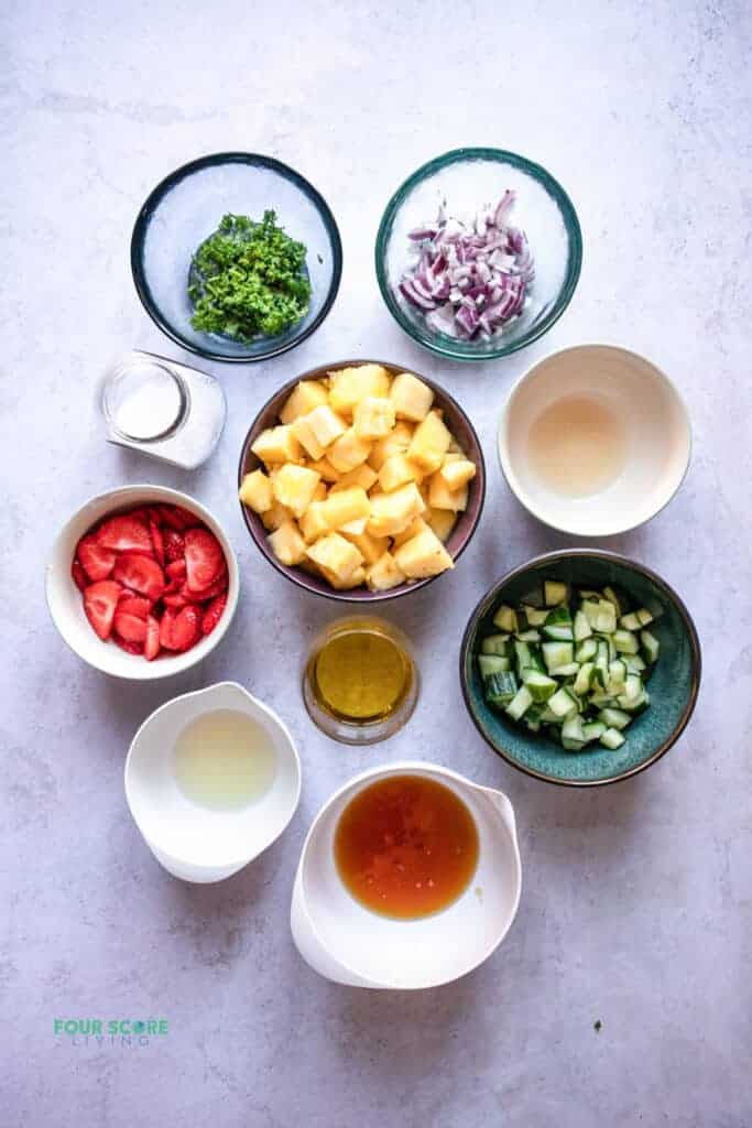 top view photo of ingredients to make pineapple salad in separate bowls.