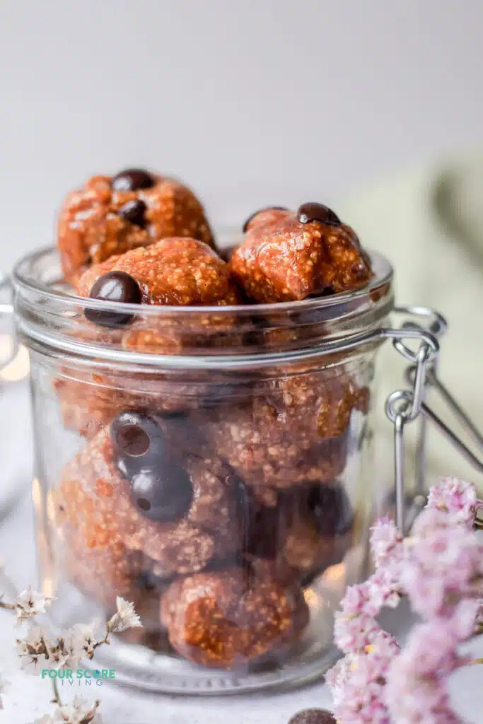 closeup view of protein cookie dough balls, in a jar with a latch top.