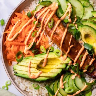 Top view photo of Salmon Rice Bowl, in a bowl and ready to serve. There is a kitchen towel next to the bowl.