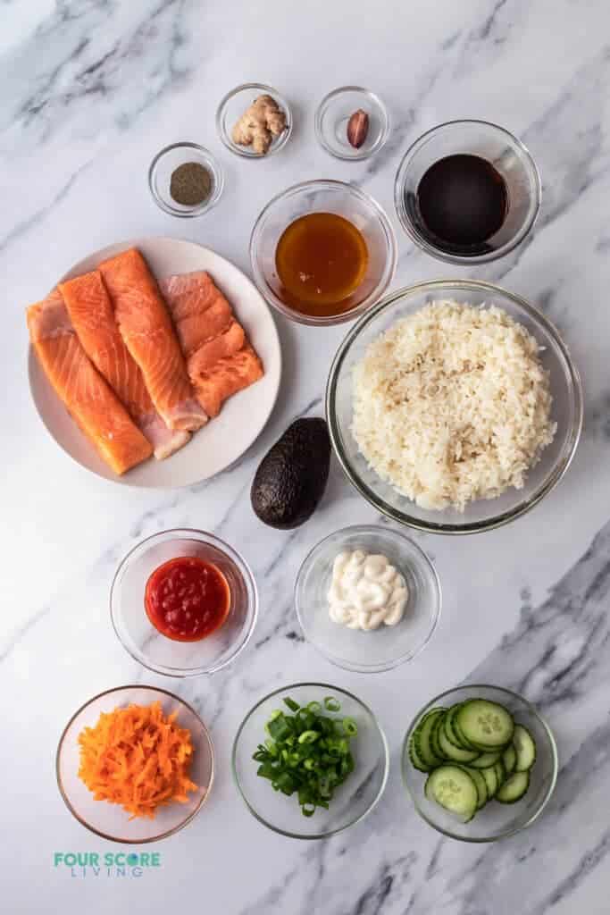 Top view photo of all the ingredients to make Salmon Rice Bowl, in separate bowls.