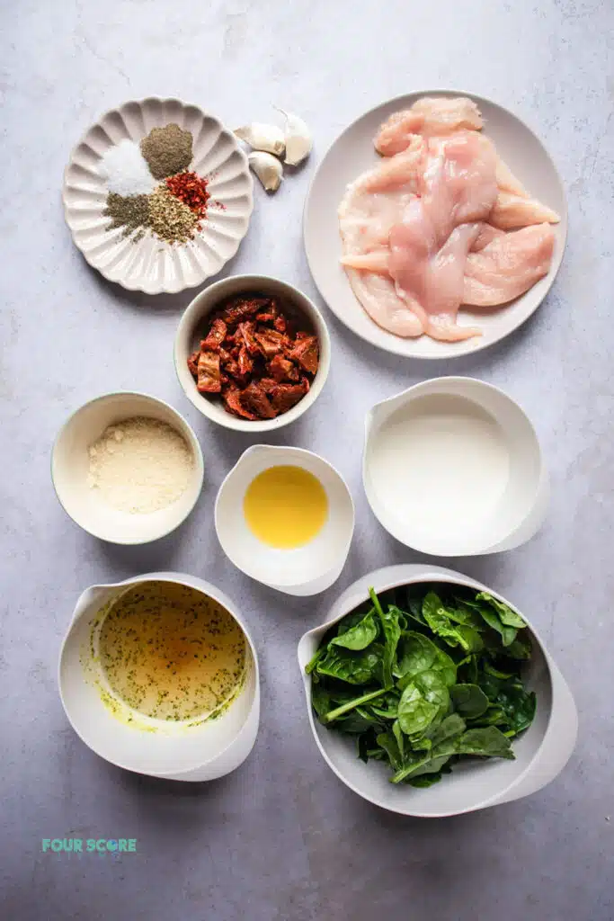 top view photo of ingredients to make tuscan chicken in separate white bowls