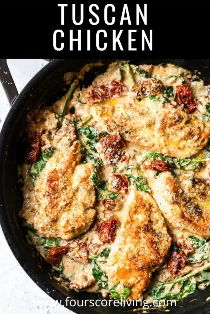 pinterest photo of a closeup of tuscan chicken in a cast iron skillet