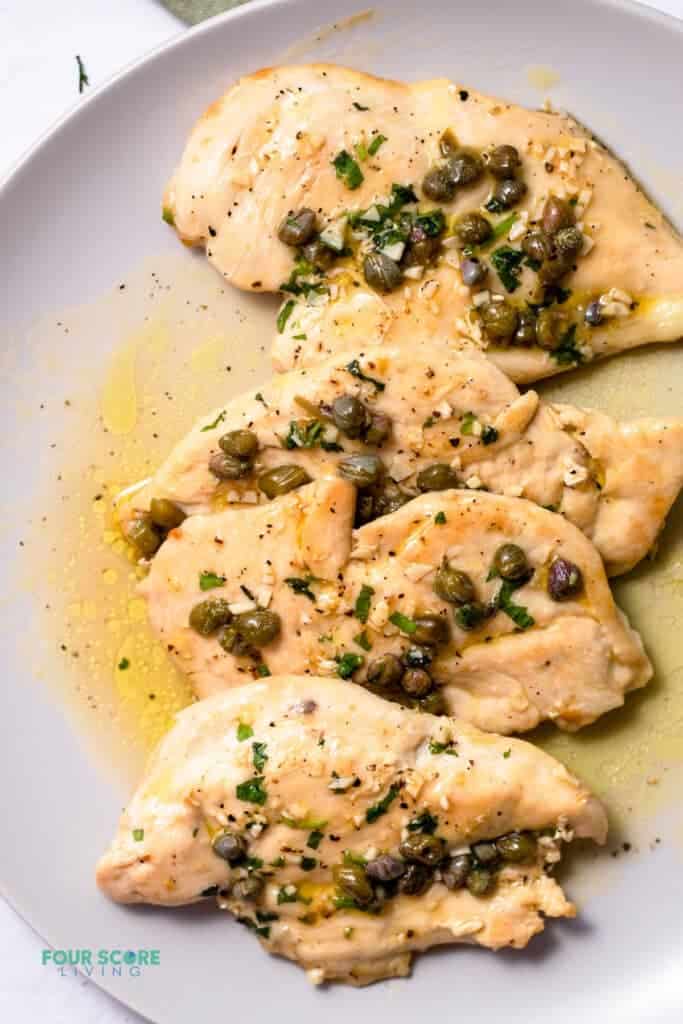 Top view photo of Chicken Paillard on a plate with capers on top.
