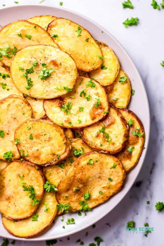 Top view photo of Cottage Fries on a white plate, garnished with finely chopped parsley.