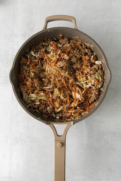 Top view photo of a skillet with all the ingredients to make Egg Roll in a Bowl all mixed together and cooked until warmed through.