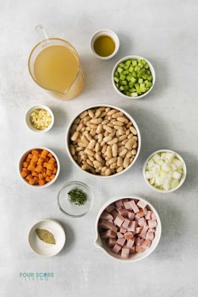 Top view photo of all the ingredients to make Ham and White Bean Soup, in separate bowls.