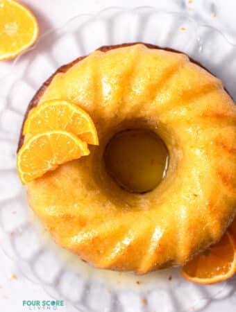 Top view photo of Italian Hangover Cake on a glass serving platter with orange slices placed around the cake in the decorative manner.