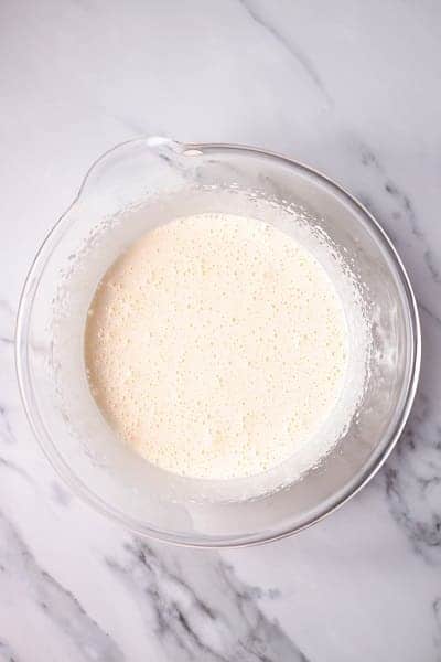 Top view photo of oil and butter mixed into the wet ingredients for Italian Hangover cake, in a clear bowl.