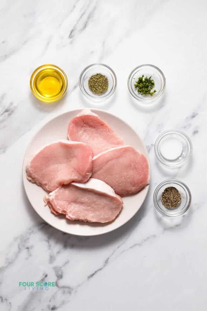 Top view photo of all the ingredients to make Pan Seared Pork Chops, in separate bowls.