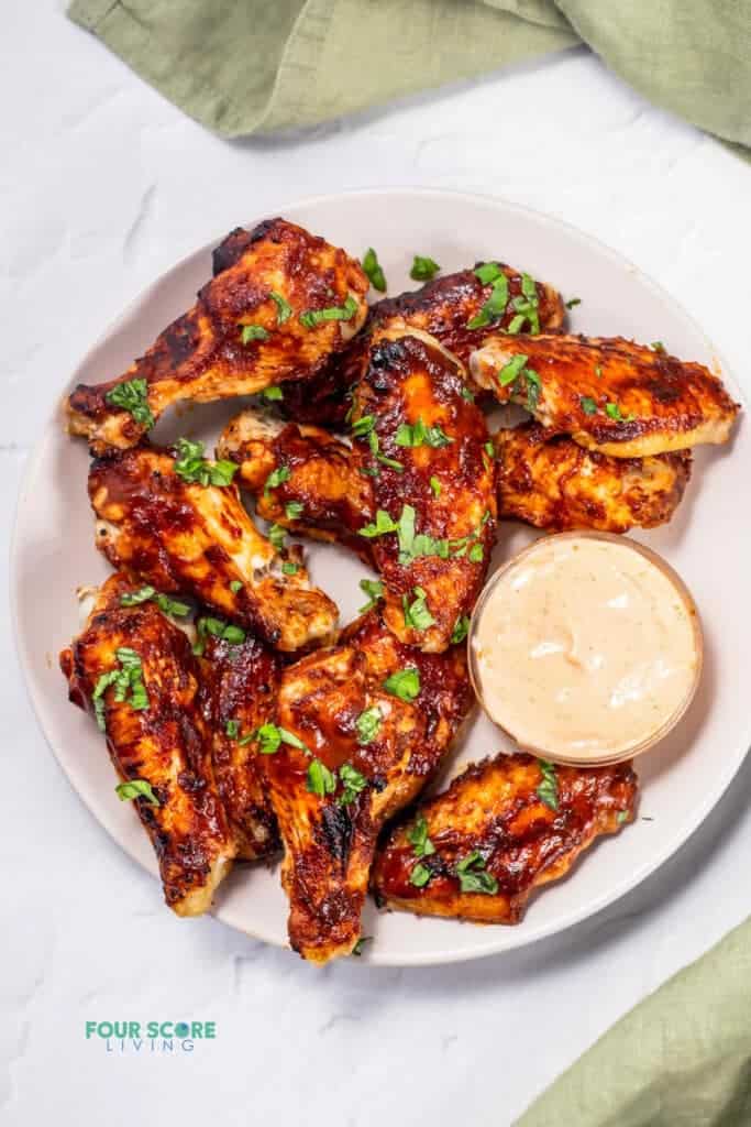 keto chicken wings on a white plat with sauce