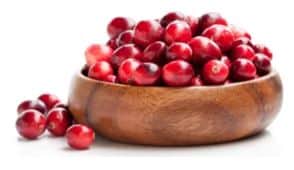 a wooden bowl full of cranberries