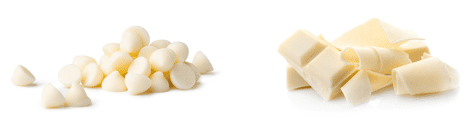 Small pile of white chocolate chips on a white background, three squares of white chocolate with shaved curls of white chocolate.