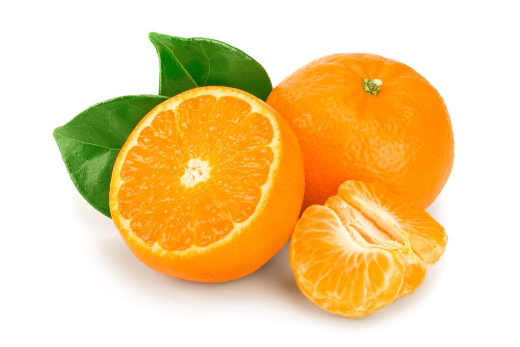 One whole tangerine fruit, one tangerine fruit sliced in half and three wedges of tangerine fruit with 2 green leaves in isolated on a white background.