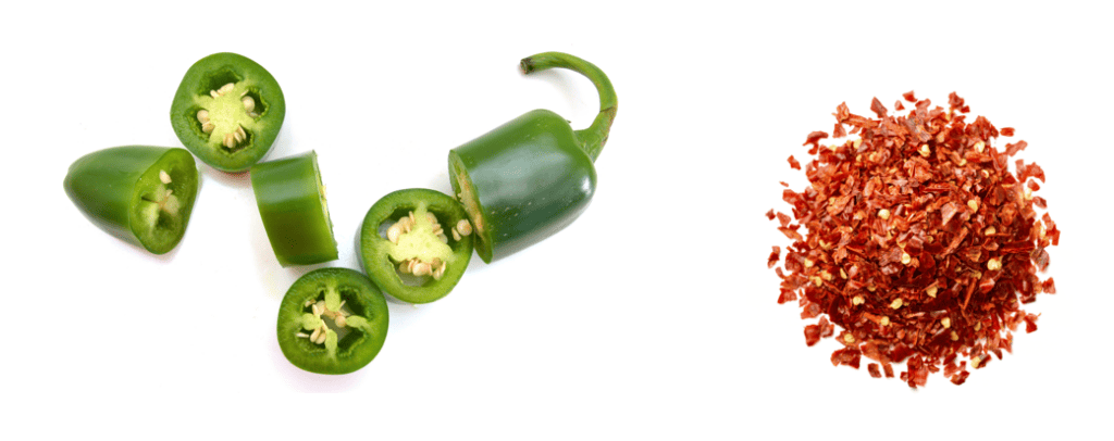 Fresh green jalapeno pepper sliced into thick discs and a circular pile of dry red pepper flakes all from an aerial view on a white background.