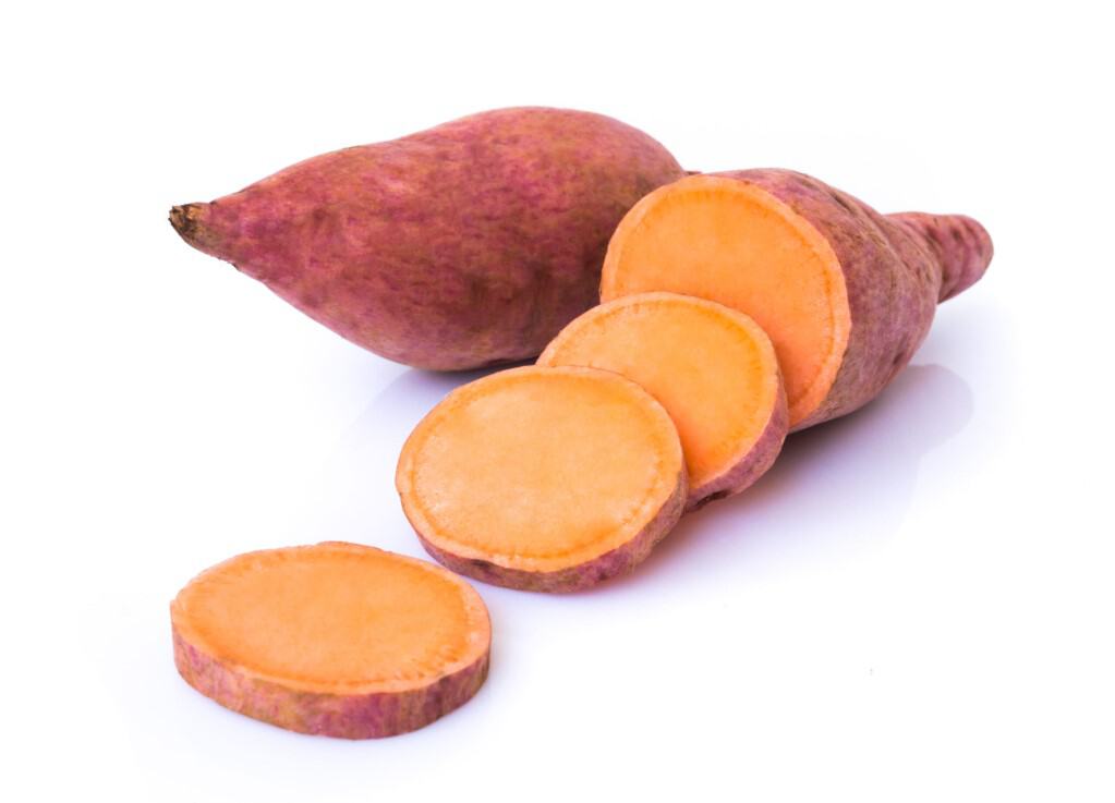 One whole raw sweet potato and one sweet potato with 3 disc slices on white background.