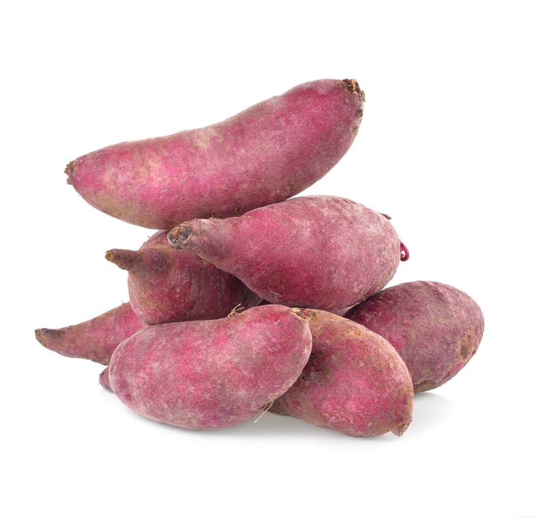 Seven whole, raw sweet potatoes in a pile on a white background.