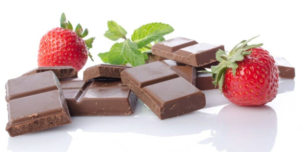 squares of milk chocolate, 2 whole strawberries and a cluster of mint leaves