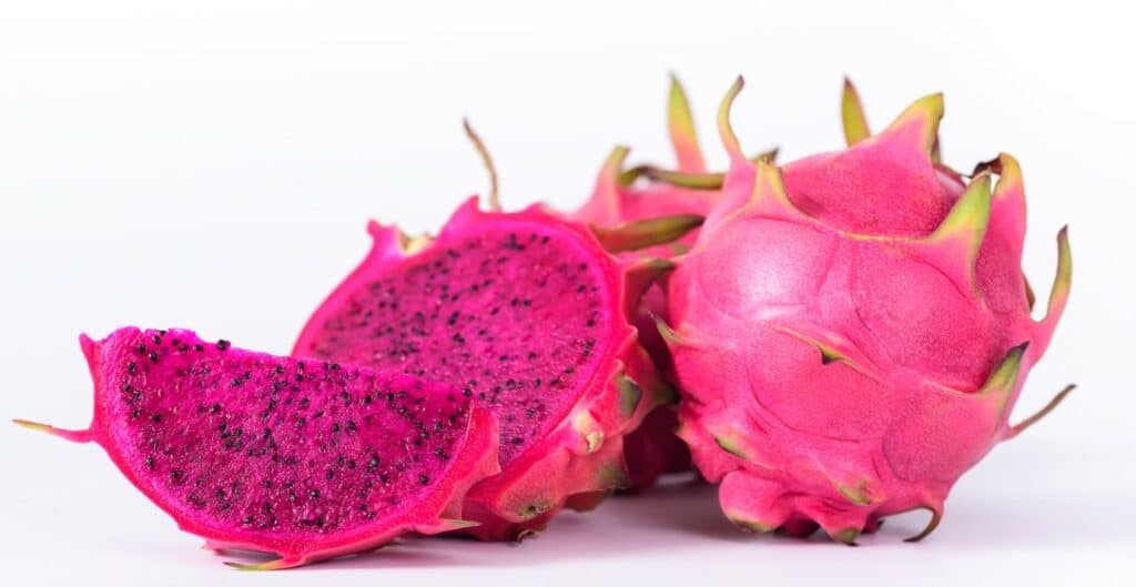 Fresh dragon fruit with pink skin and pink flesh.