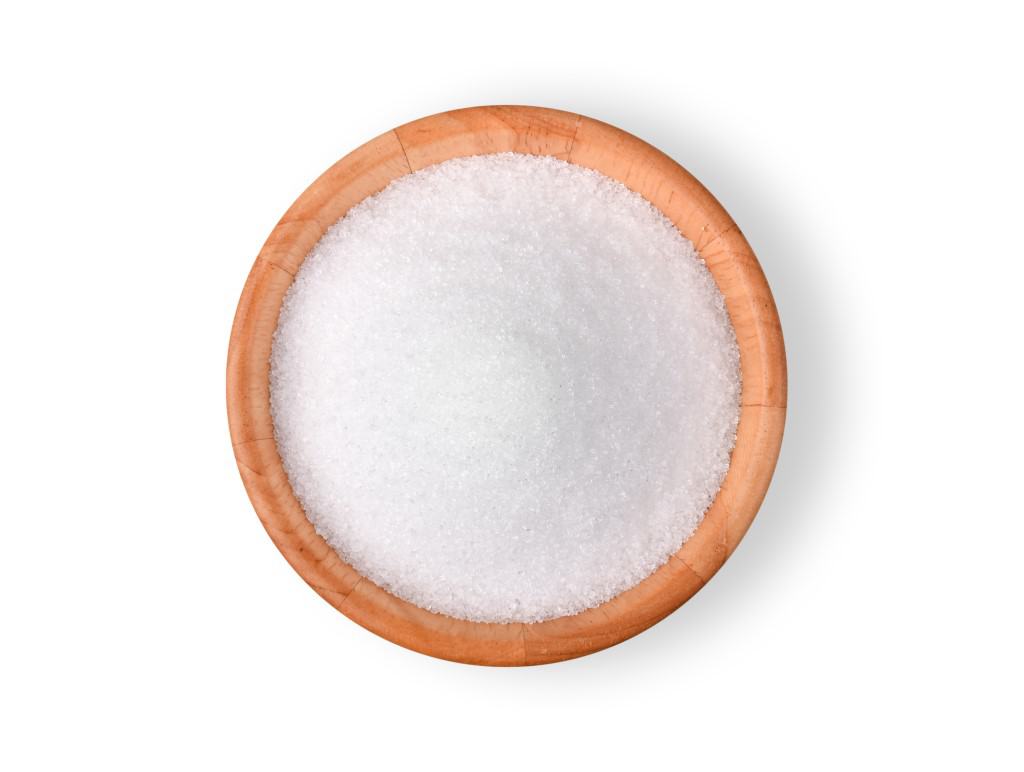 Small medium wood colored dish of granulated xylitol on white background.