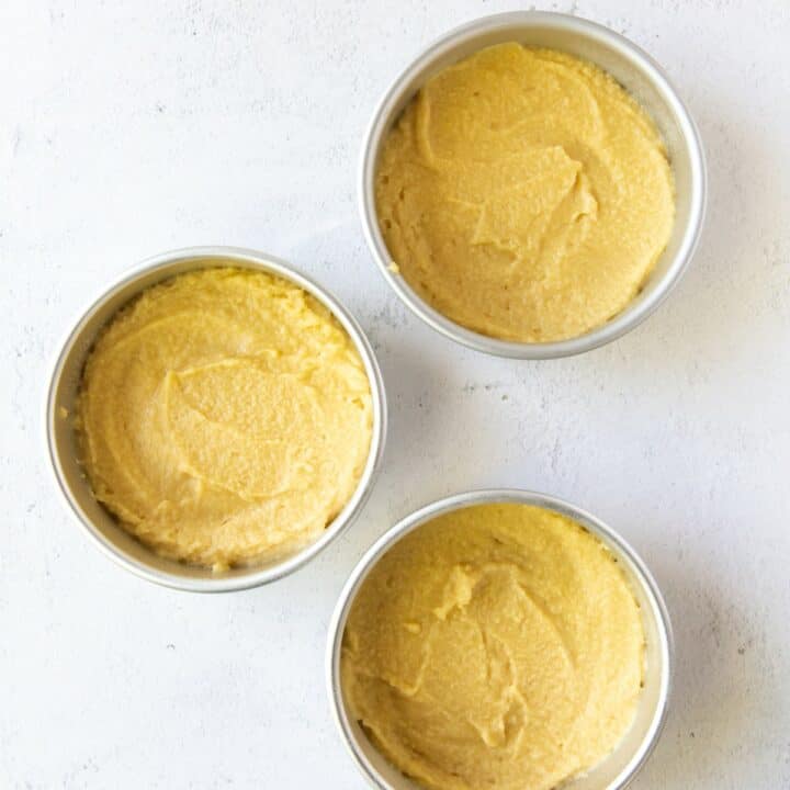 3 round cake pans evenly filled with keto lemon cake batter.